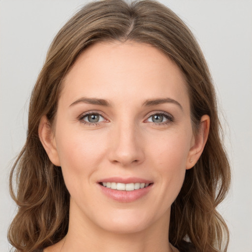 Joyful white young-adult female with long  brown hair and grey eyes