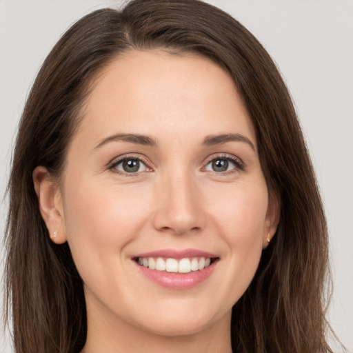 Joyful white young-adult female with long  brown hair and brown eyes