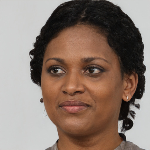 Joyful black young-adult female with short  black hair and brown eyes