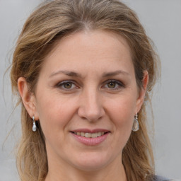 Joyful white adult female with medium  brown hair and grey eyes