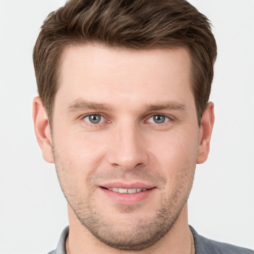 Joyful white young-adult male with short  brown hair and grey eyes