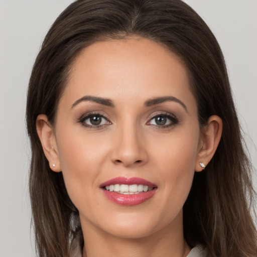 Joyful white young-adult female with long  brown hair and brown eyes