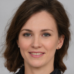 Joyful white young-adult female with long  brown hair and green eyes