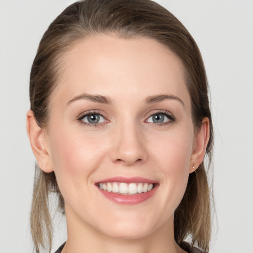 Joyful white young-adult female with medium  brown hair and grey eyes