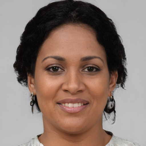 Joyful latino adult female with medium  brown hair and brown eyes