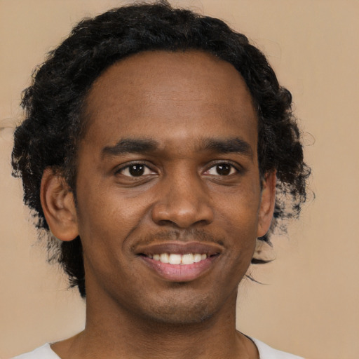 Joyful black young-adult male with short  black hair and brown eyes