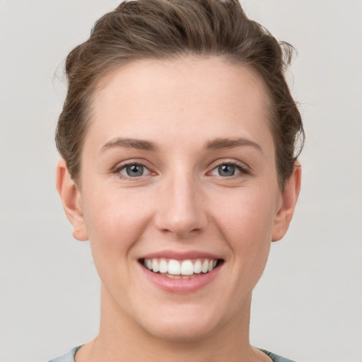 Joyful white young-adult female with short  brown hair and grey eyes