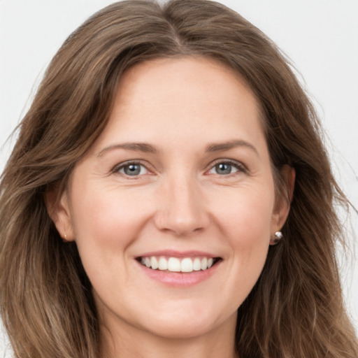 Joyful white young-adult female with long  brown hair and grey eyes