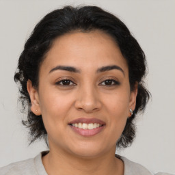 Joyful latino young-adult female with medium  brown hair and brown eyes