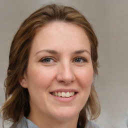 Joyful white adult female with medium  brown hair and grey eyes