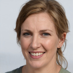 Joyful white adult female with medium  brown hair and grey eyes