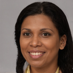 Joyful black adult female with long  brown hair and brown eyes