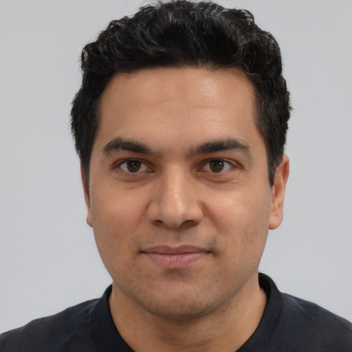 Joyful latino young-adult male with short  black hair and brown eyes
