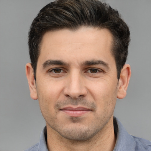 Joyful white young-adult male with short  black hair and brown eyes