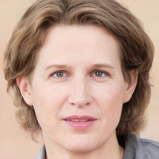 Joyful white adult female with medium  brown hair and grey eyes