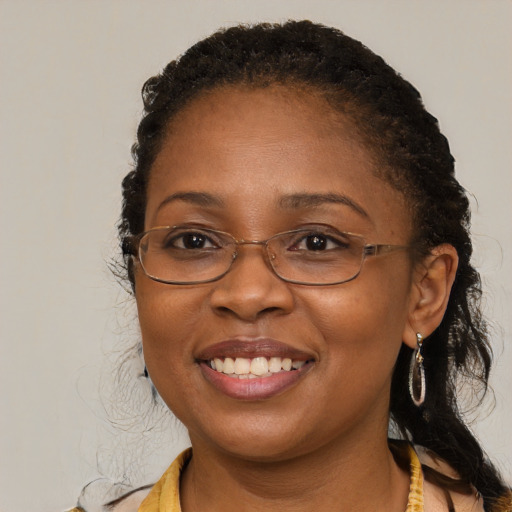 Joyful black adult female with long  brown hair and brown eyes