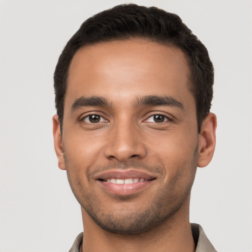 Joyful latino young-adult male with short  brown hair and brown eyes