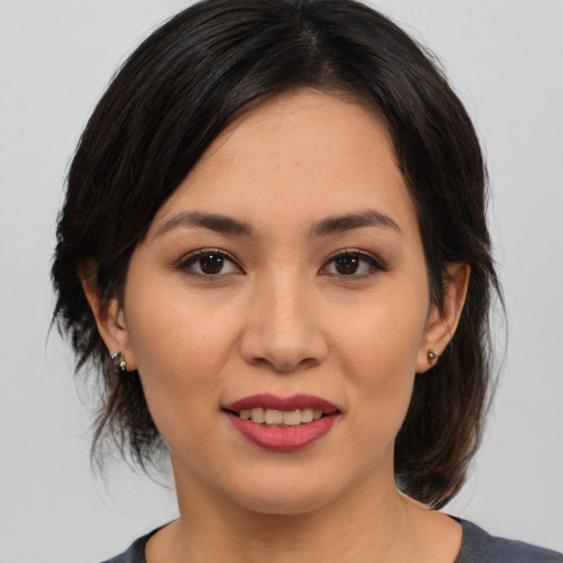 Joyful asian young-adult female with medium  brown hair and brown eyes