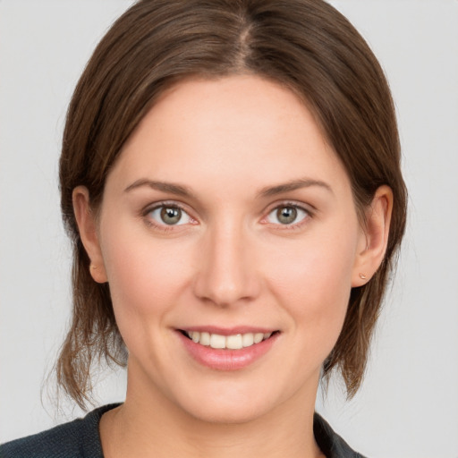 Joyful white young-adult female with medium  brown hair and grey eyes