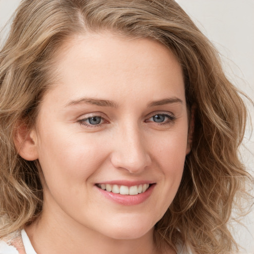 Joyful white young-adult female with long  brown hair and blue eyes