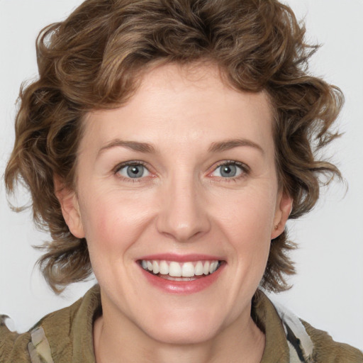 Joyful white young-adult female with medium  brown hair and green eyes