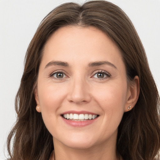 Joyful white young-adult female with long  brown hair and grey eyes