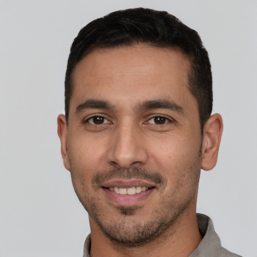 Joyful white young-adult male with short  black hair and brown eyes