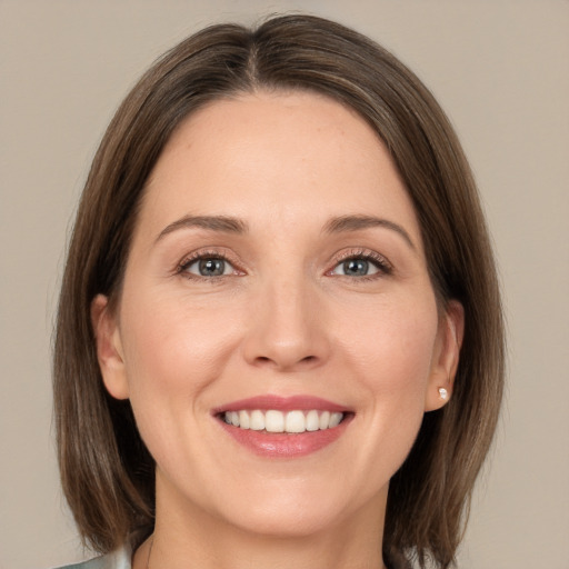 Joyful white young-adult female with medium  brown hair and grey eyes