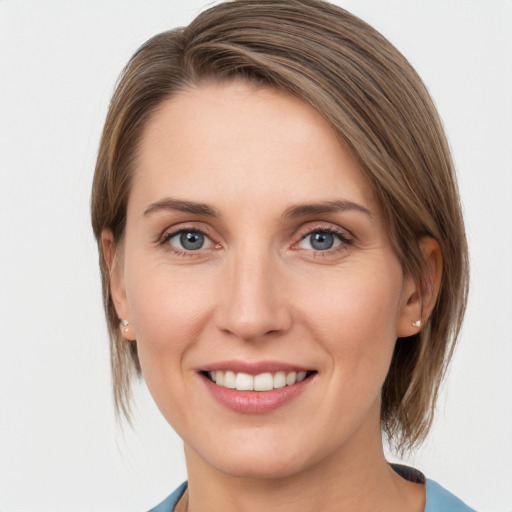 Joyful white young-adult female with medium  brown hair and grey eyes