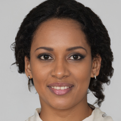 Joyful black young-adult female with medium  brown hair and brown eyes