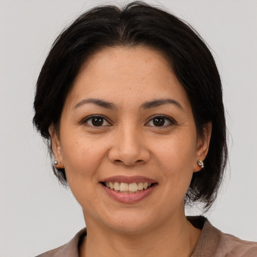 Joyful latino young-adult female with medium  brown hair and brown eyes