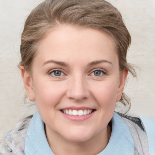 Joyful white young-adult female with medium  brown hair and blue eyes