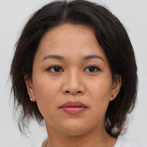 Joyful asian adult female with medium  brown hair and brown eyes