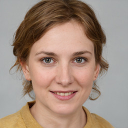 Joyful white young-adult female with medium  brown hair and grey eyes