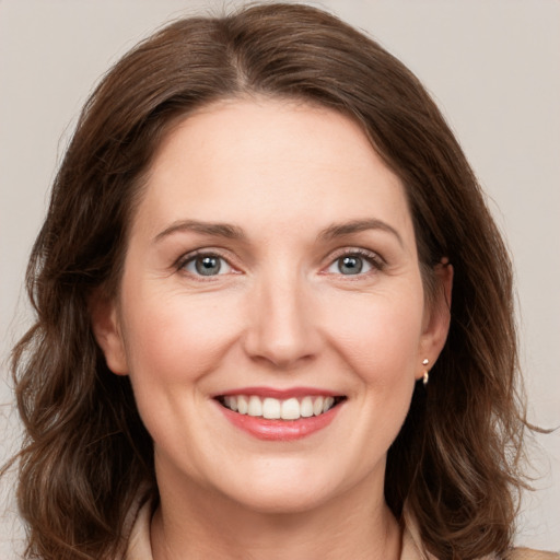 Joyful white young-adult female with medium  brown hair and grey eyes