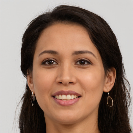 Joyful latino young-adult female with long  brown hair and brown eyes