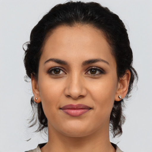 Joyful latino young-adult female with medium  brown hair and brown eyes