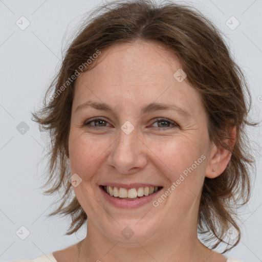 Joyful white adult female with medium  brown hair and grey eyes