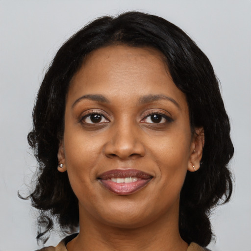 Joyful black young-adult female with medium  black hair and brown eyes