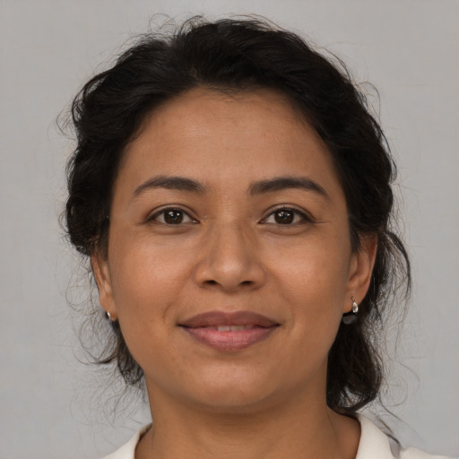 Joyful latino adult female with medium  brown hair and brown eyes