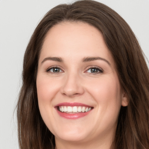 Joyful white young-adult female with long  brown hair and grey eyes