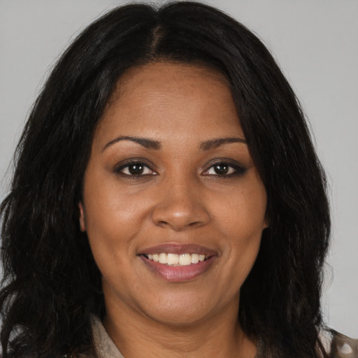 Joyful black adult female with long  brown hair and brown eyes