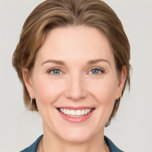 Joyful white young-adult female with medium  brown hair and blue eyes