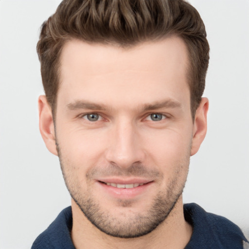 Joyful white young-adult male with short  brown hair and grey eyes