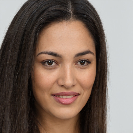 Joyful latino young-adult female with long  brown hair and brown eyes