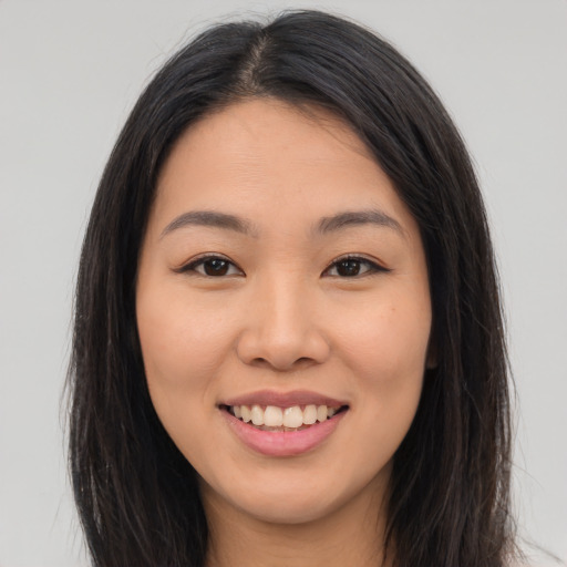 Joyful latino young-adult female with long  brown hair and brown eyes