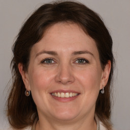 Joyful white adult female with medium  brown hair and grey eyes