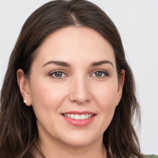 Joyful white young-adult female with long  brown hair and grey eyes