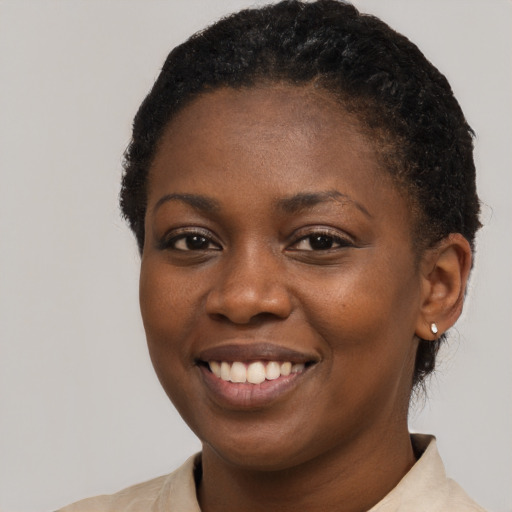 Joyful black young-adult female with short  brown hair and brown eyes