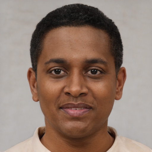Joyful black young-adult male with short  black hair and brown eyes